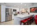 Bright kitchen with stainless steel appliances, white cabinets, and a breakfast bar with red stools at 7318 S Mcallister Ave, Tempe, AZ 85283