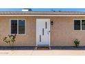 Inviting front entrance with a modern white door, stylish lighting, and desert landscaping at 902 E Wahalla Ln, Phoenix, AZ 85024
