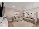 Cozy living room featuring a sectional sofa, a large TV, and modern decor at 902 E Wahalla Ln, Phoenix, AZ 85024