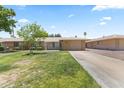Inviting single-level home featuring a lush green lawn and a convenient attached garage at 9434 W Greenway Rd, Sun City, AZ 85351
