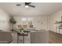Neutral living room with cozy seating, a ceiling fan, and bright light from the dual windows at 9735 W Altadena Dr, Casa Grande, AZ 85194
