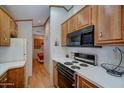 Well-lit kitchen with white countertops, wood cabinets, and modern appliances at 111 S Greenfield Rd # 405, Mesa, AZ 85206