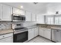Bright kitchen showcasing modern stainless steel appliances, granite countertops, and white cabinetry at 11217 E Laurel Ln, Scottsdale, AZ 85259