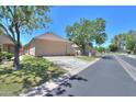 Single-story home with a well-manicured lawn and three-car garage, perfect for car enthusiasts at 1417 E Marshall Ave, Phoenix, AZ 85014