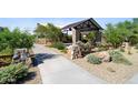 Community park featuring a shaded picnic area, playground equipment, and gravel walking paths at 14651 W Sand Hills Rd, Surprise, AZ 85378