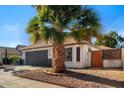 Landscaped front yard featuring a mature palm tree, and an attached two-car garage at 1736 E Bluefield Ave, Phoenix, AZ 85022