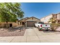 Charming home featuring desert landscaping, an American flag, and an attached two-car garage at 17611 W Watson Ln, Surprise, AZ 85388