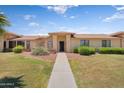 Inviting single-story home featuring lush green lawn and manicured landscaping at 18416 N Spanish Garden Dr, Sun City West, AZ 85375