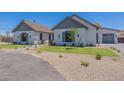 Charming single Gathering home featuring lush green lawns, gravel accents, and architectural design at 2095 N 77Th Pl, Mesa, AZ 85207