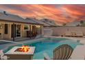 Inviting backyard featuring a swimming pool, fire pit, outdoor dining, and cozy seating at 21061 N 33Rd Dr, Phoenix, AZ 85027