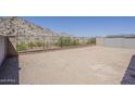 Spacious, undeveloped backyard with wrought iron and block fence offers mountain views and plenty of space for landscaping at 21276 W Mariposa St, Buckeye, AZ 85396