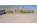 Backyard with a low brick retaining wall and a wrought iron fence showing desert vegetation on a hill at 21276 W Mariposa St, Buckeye, AZ 85396