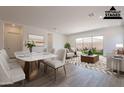 Staged living room and dining area features stylish furniture, neutral tones, and sliding doors to the backyard at 21427 W Meadowbrook Ave, Buckeye, AZ 85396