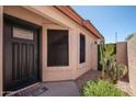 Inviting front entrance with a modern black door, cactus accents, and a decorative welcome mat at 21632 N 48Th St, Phoenix, AZ 85054