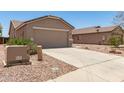 View of the home's exterior showcasing the concrete driveway and desert landscaping at 22547 W Pima St, Buckeye, AZ 85326