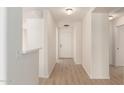 Bright hallway with wood-look flooring and white walls leading to the front door at 22547 W Pima St, Buckeye, AZ 85326