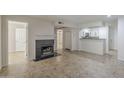 Open concept living room with tile floors and a cozy fireplace leading into the kitchen at 2333 E Southern Ave # 1023, Tempe, AZ 85282