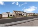 Wide street view displaying a collection of stylish homes each adorned with welcoming front yards at 24254 W Agora Ln, Buckeye, AZ 85326