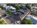 Spacious newly constructed home showcases modern design with a dark roof amidst lush green surroundings and neighborhood streets at 3028 N 47Th St, Phoenix, AZ 85018