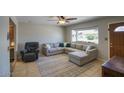 Comfortable living room with a large window, ceiling fan, and plush seating arrangement at 3203 W Libby St, Phoenix, AZ 85053