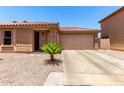 Charming single-story home featuring a terracotta roof, desert landscaping, and an attached two-car garage at 3438 S Bowman Rd, Apache Junction, AZ 85119