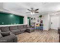 Spacious living room featuring hardwood floors, a gray sofa, and a ceiling fan for enhanced comfort at 3438 S Bowman Rd, Apache Junction, AZ 85119