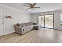 Cozy living room featuring modern ceiling fan, sliding glass doors, and gray sofa at 3500 N Hayden Rd # 203, Scottsdale, AZ 85251