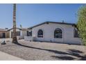 Single story home with white brick, desert landscaping, arched windows, and a palm tree at 5028 W Shangri La Rd, Glendale, AZ 85304