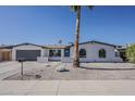 Single story home with white brick, desert landscaping, and an attached two car garage at 5028 W Shangri La Rd, Glendale, AZ 85304