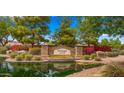 Charming community entrance with stone signage, manicured landscaping, mature trees, and a serene water feature at 549 E Benrich Dr, Gilbert, AZ 85295