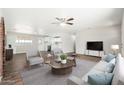 Inviting living area with an open layout to the kitchen, stylish seating, and hardwood floors at 6223 W Earll Dr, Phoenix, AZ 85033
