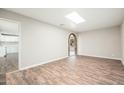 Inviting living room showcasing wood-look floors and a brick archway to another room at 6223 W Earll Dr, Phoenix, AZ 85033