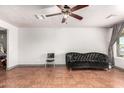 Living room with tile floor, ceiling fan and view of the exterior through the window at 6335 W Osborn Rd, Phoenix, AZ 85033