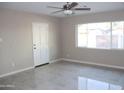 Bright bedroom featuring tile flooring, a ceiling fan, and a large window for natural light at 6702 E Almeria Rd, Scottsdale, AZ 85257
