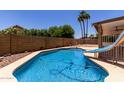 Inviting backyard pool featuring a slide, surrounded by a block fence for privacy at 723 E Piute Ave, Phoenix, AZ 85024