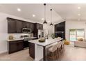 Modern kitchen featuring a large island with seating, stainless steel appliances, and views of the pool at 862 W Javelina Ave, Mesa, AZ 85210