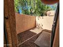 A quaint, enclosed patio features gravel ground cover, mature trees, and stucco walls at 8940 W Olive Ave # 39, Peoria, AZ 85345