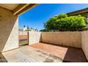 Private outdoor patio featuring brick and concrete flooring, a gate, and views of lush landscaping at 11026 N 28Th Dr # 81, Phoenix, AZ 85029