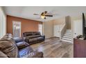 Living room with wood floors, staircase, and a comfortable leather sofa at 12720 W Cantenia Rd, Avondale, AZ 85392