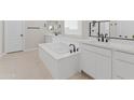 Elegant bathroom with soaking tub, dual vanities, and black fixtures at 14274 W Sand Hills Rd, Surprise, AZ 85387