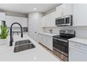 Modern white kitchen with stainless steel appliances, quartz countertops, and sleek cabinetry at 14274 W Sand Hills Rd, Surprise, AZ 85387