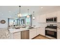 Modern kitchen with stainless steel appliances, white cabinets, and granite countertops at 1482 W Ridge Rd, Apache Junction, AZ 85120