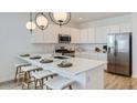 Bright kitchen featuring island with seating, modern pendant lighting, and stainless steel appliances at 1482 W Ridge Rd, Apache Junction, AZ 85120