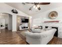 Comfortable living room with cozy fireplace, wood floors, a stylish ceiling fan, and modern decor at 15034 N 30Th St, Phoenix, AZ 85032