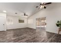 Bright open living room with a sliding glass door, ceiling fan, and wood-look floors at 16118 W Morning Glory St, Goodyear, AZ 85338