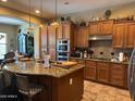 Spacious kitchen with a large island, granite countertops, and wooden cabinets with stainless steel appliances at 18008 W Ocotillo Ave, Goodyear, AZ 85338