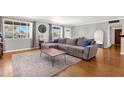 Cozy living room featuring a grey sofa, wooden floors, natural light, and a decorative ladder at 2118 W Cactus Wren Dr, Phoenix, AZ 85021