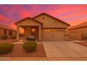 Inviting single-story home showcasing a covered porch, easy care landscaping, and a two-car garage at 22403 W Harrison St, Buckeye, AZ 85326