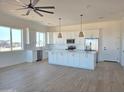 Open-concept kitchen with white cabinets, stainless steel appliances and a large island at 28151 N Faded Creek Dr, Florence, AZ 85132