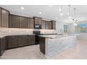 Modern kitchen with gray cabinets, granite countertops, and stainless steel appliances at 37460 W Giallo Ln, Maricopa, AZ 85138